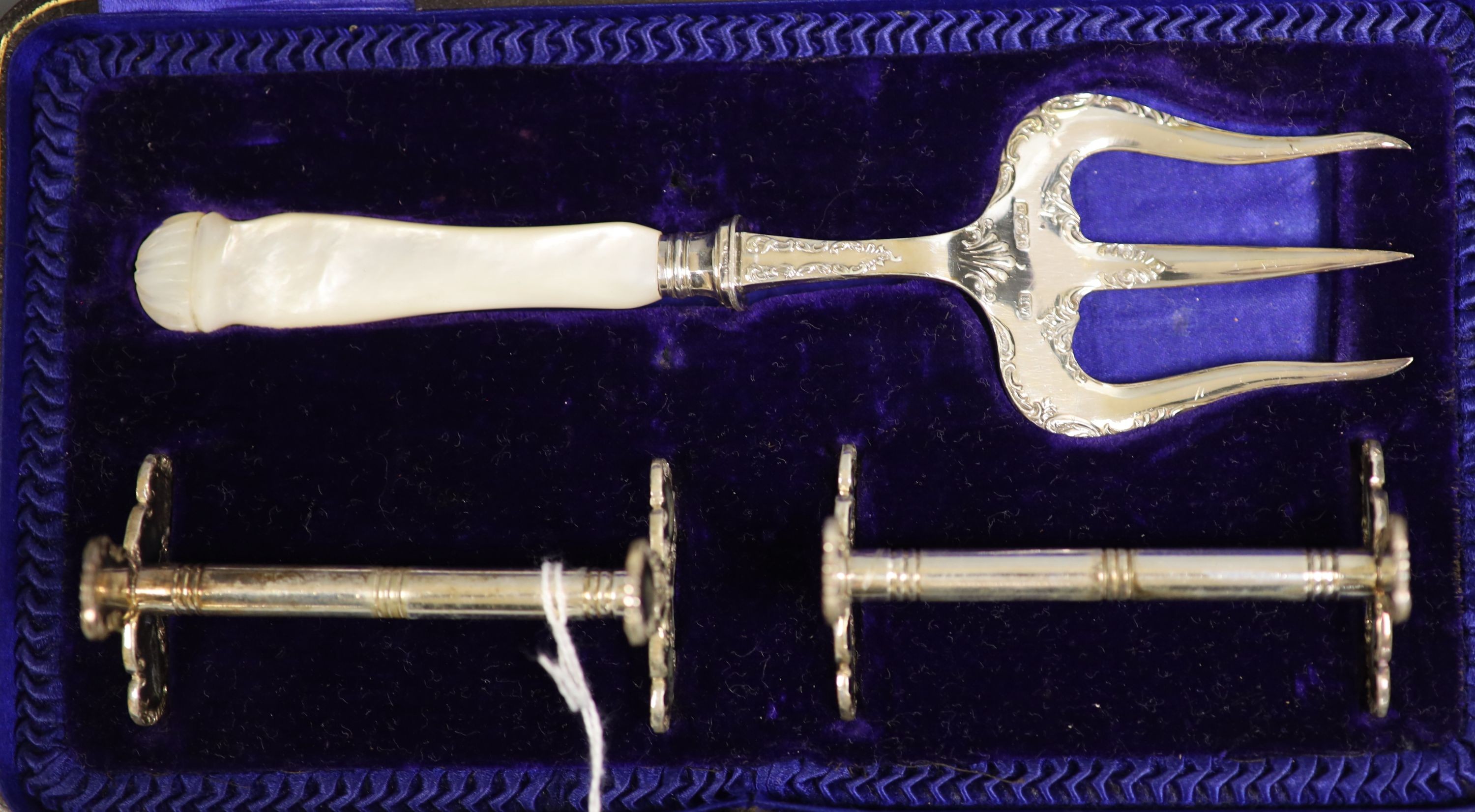 A 1920's silver small mug, a cased pair of silver pepperettes and a cased pair of knife rests and fork.